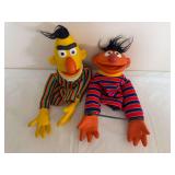 Pair of Bert and Ernie hand puppets with molded vinyl heads and hands, fabric clothing and black synthetic hair. Shows general age-related wear.