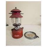 Coleman Model 200A pressure lantern with red fount and red porcelain ventilator, clear Coleman globe and wire bail handle; marked 11/62. Includes accessory safe plate as shown and displays paint wear,