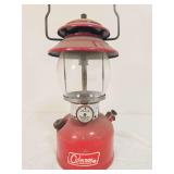 Coleman Model 200A pressure lantern marked 11/66, with red painted fount, matching red porcelain ventilator, clear Coleman globe and wire bail handle. Shows paint wear, oxidation and age-related surfa