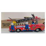 Vintage tin lithographed fire engine with colorful firefighter graphics, ladder and driver figure, together with additional firetruck and firefighting toys as shown. Mixed materials, makers and ages.