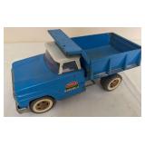 Vintage Tonka pressed-steel hydraulic dump truck in blue and white with raised dump bed. Features Tonka Hydraulic graphics and whitewall-style tires.