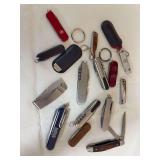 Group of assorted pocket knives and multi-function Swiss Army-style knives, including an NRA promotional knife, stainless examples and traditional wood-handled folding knife. Includes keychain-sized a