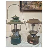 Coleman Models 275 & 228E Lanterns – Marked 3/78 & 5/42. Includes brown Model 275 double-mantle lantern and vintage green wide-ventilator 228E, both with clear globes and wire bail handles; shows ox