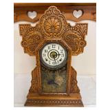 Antique mantel clock with highly detailed carved oak case, Arabic-numeral dial and decorative lower glass with gold floral scene. Manufacturer not identified