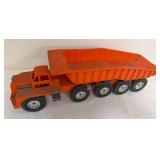 Vintage Eldon large-scale orange plastic dump truck with 10 wheels and oversized tilting dump body. Shows general age-related wear and use.
