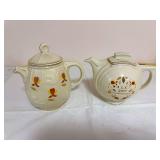 Two Hall Autumn Leaf lidded teapots with gold trim, including an embossed-body teapot marked “Made Especially for The Autumn Leaf Club by The Hall China Co. 1985” and a round-bodied teapot commemo