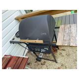 Sunbeam Model 340 outdoor gas grill with lidded cooking area, side shelf, wheeled cart and control panel as shown. Shows age-related outdoor wear.