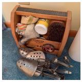 Vintage wood shoe shine kit marked Esquire Footman Deluxe with brushes, polish and cloths, accompanied by assorted metal shoe trees and related shoe-care items.