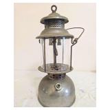 Akron Lamp Company No. 103 Pressure Lantern. Vintage double-mantle pressure lantern with gray metal fount, matching ventilator, clear cylindrical globe and wire bail handle; shows oxidation, finish we