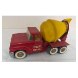 Vintage Structo Ready Mix pressed-steel cement mixer truck with red cab, yellow rotating mixer drum and dual rear wheels. Whitewall-style tires with general age-related wear.
