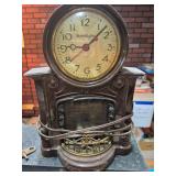 Vintage MasterCrafters Fireplace-Style Electric Mantel Clock. Decorative brown electric clock with round numeral dial above a simulated fireplace opening and ornamental brass-tone grate; marked Master