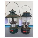 Coleman Models 290 & 228E Lanterns – Marked 11/84 & 12/62. Green pressure lanterns with clear globes and wire bail handles, including wide-ventilator 228E; shows age-related wear, oxidation and surf