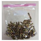 Large resealable bag of loose 9mm handgun ammunition with brass cases and copper-colored bullets as shown.