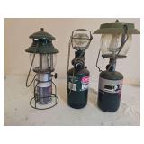 Three portable propane lanterns in assorted styles and finishes with glass globes and carrying handles as shown; mixed makers and condition.