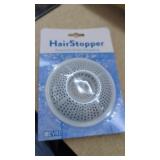 HairStopper, a white plastic strainer designed to
