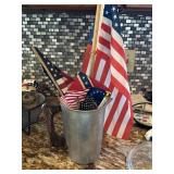 Aluminum pitcher containing several small flags &