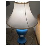 Blue glass table lamp with a white linen shade
