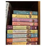 Collection of physical books, specifically cozy