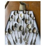 Mixed demitasse flatware in a silver creamer cup