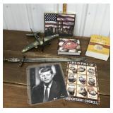 Ceremonial sword, toy airplane, books, sign,