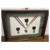 Vintage swimming medals in a frame