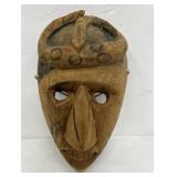 Wood carved face w/ snake on head.