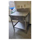 A Stainless Steel Table with back splash lower sh