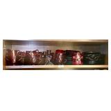 Top shelf in upper cabinet with ruby red glass