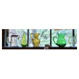 Colored glass and old syrup pitcher in window