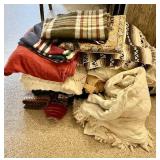 Huge stack of blankets, throws, rugs, towels