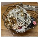 Metal basket full of costume jewelry