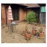 Contents of patio--flower pots, table, umbrella