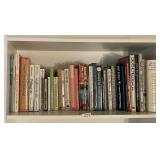 Group of books on white laminate shelf