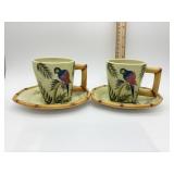 Two parrot tea cups with saucers