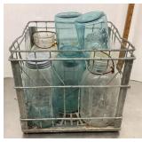 7 old canning jars in metal crate