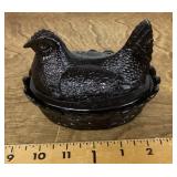 Black glass hen on nest