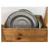 8 hubcaps in wooden fruit crate