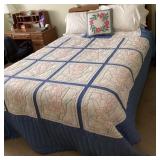 Queen bed with storage headboard and quilt