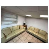 (2) large leather couches with coffee table and lamp