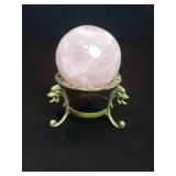 Rose quartz sphere on a decorative brass stand