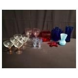 Group of colored glass stemware case and candle