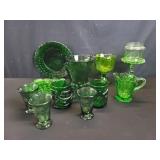 Group of emerald green glass pitchers. Plates.