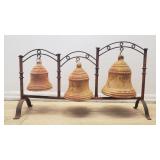 Three rustic terracotta bells on an iron stand