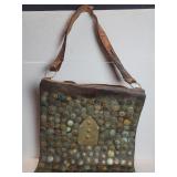 Antique leather messenger bag adorned with a
