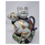 Japanese Kutani porcelain man holding dog figure