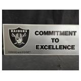 Raiders cardboard sign "Commitment to Excellence"