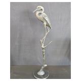 Bronze heron on a branch sculpture on a black
