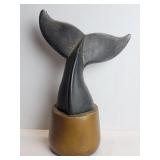 Cast iron whale tail sculpture on a wood base