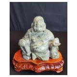 Vintage stone Buddha figure on a wood vase