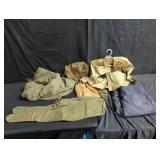 Group of military clothes, bags, and rifle cases